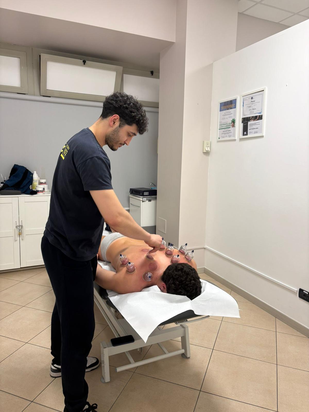 Il Dott. Luca Mottaran durante un trattamento con coppette sulla schiena di un paziente
